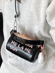 Petit sac à bandoulière noir cylindrique avec lettrage rose et pendentif en peluche