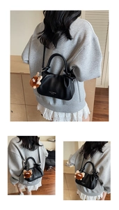 Close-up of black pleated leather crossbody bag with a cute brown bear charm detail
