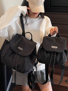 Minimalist black nylon backpack for women in large and small sizes on stairs