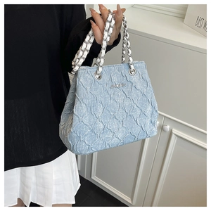Detail of light blue pleated bag with silver chain strap and brand logo on leather