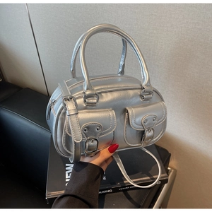Detail of silver metallic Boston bag with buckle pockets and polished synthetic leather