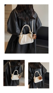Detail of cream pleated crossbody bag with lychee grain leather and plush animal charm