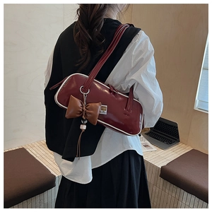 Sac baguette marron avec breloque nœud vu de dos porté à l'épaule pour femme