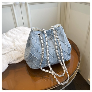 Detail of light blue denim bucket bag with quilted texture and silver ONGPIN logo