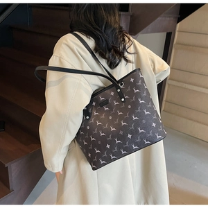 Detail view of large printed tote bag on shoulder, showing size scale and pattern