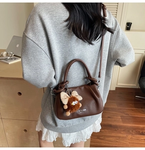 Brown lychee leather shoulder bag featuring a cute plush butterfly doll charm