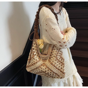 Close-up of hand-woven straw tote featuring hollow geometric patterns and leather strap