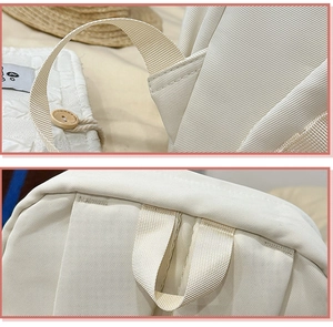 Detailed close-up of reinforced stitching and durable fabric on beige student backpack