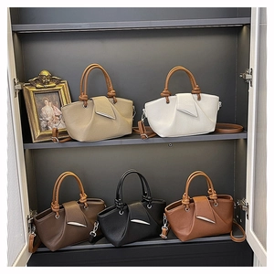 Selection of litchi grain leather bucket bags in five colors on a retail display stand