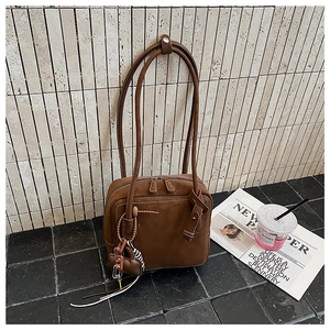 Detail of dark brown leather tote with dual zippers and long thin shoulder straps