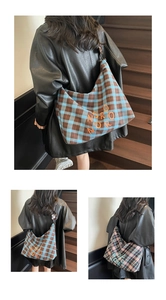 Détail de grands sacs cabas à carreaux avec broderie NORO NORO sur des escaliers