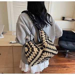 Detail of hand-knitted tote bag with wave pattern and ruffled black shoulder strap