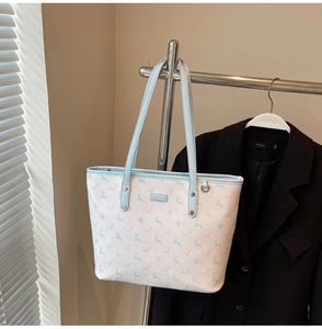 Detailed view of large capacity blue deer print tote bag hanging on a rack with shoulder strap