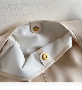 Close-up of beige tote bag interior featuring premium golden magnetic snap buttons