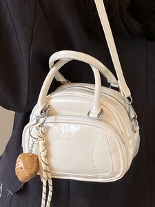 White glossy patent leather pillow handbag with adjustable strap and designer logo