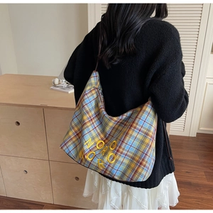 Détail du sac à bandoulière à carreaux bleu et jaune avec broderie et longue lanière