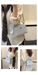 Close-up of silver sequin handbag with crocodile texture and metal twist lock detail