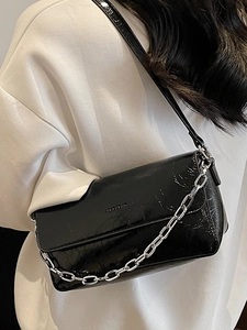 Minimalist black baguette chain bag in wrinkled glossy leather for women's crossbody wear