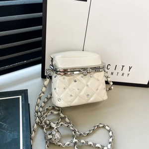 Detail of white quilted mini bag with silver kiss-lock clasp and rhinestone studs