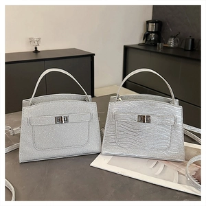 Detail of silver glitter handbags featuring metallic twist locks and textured shimmer finish
