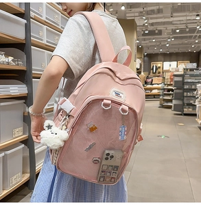 Pink school backpack detail showing front mesh pocket and cute plush bear accessory