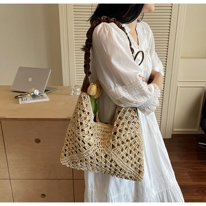 Detail of hand-woven hollow straw tote bag with brown leather ruffled shoulder strap