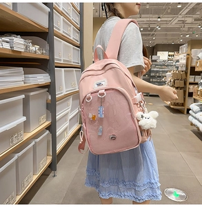 Pink school backpack detail with mesh pocket and cute plush bunny charm on side