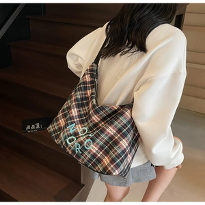 Gros plan détaillé sur la broderie d'un grand sac cabas à carreaux classiques vert et marron