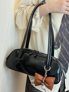 Sac bowling minimaliste noir brillant avec pendentif noeud en cuir et bandoulière chic