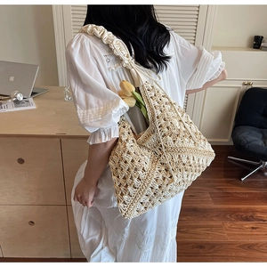 Detail of hand-woven straw shoulder bag featuring stylish wide ruffled straps and texture