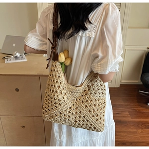 Detail of hand-woven straw tote with crochet pattern and brown leather shoulder strap