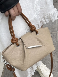 Minimalist beige lychee grain handbag with brown knotted handle and silver metal lock closure