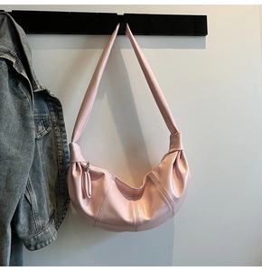 Detailed view of pink hobo bag with glossy finish and pleated shoulder strap design