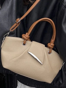 Minimalist beige pebble leather handbag with caramel handles and silver metal accents