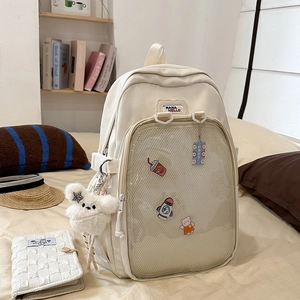 Detail of off-white canvas backpack with transparent mesh pocket and cute cartoon patches