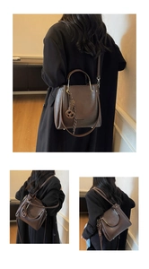 Detail view of dark coffee PU leather crossbody bag with golden hardware and braided trim