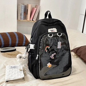 Detail of black ita bag with transparent PVC pocket for badges and plush bear charm