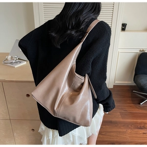 Close-up of high-quality taupe PU leather bucket bag with wide shoulder strap