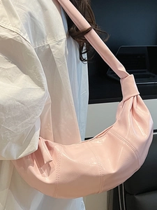 Pink glossy hobo shoulder bag with large crescent shape and knotted strap for women