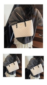 Dettaglio di una borsa tote beige con motivi geometrici e sottili manici in pelle nera
