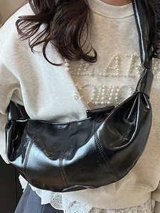 Minimalist large glossy black crescent crossbody bag for women with pleated leather details