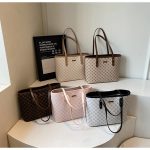 Gruppo di borse shopper monogram vintage in cinque colori su supporti geometrici bianchi