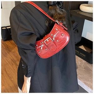 Detail view of red rivet shoulder bag with silver hardware on a black suit outfit