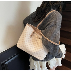 Vista laterale della borsa tote crema con motivo geometrico su una modella