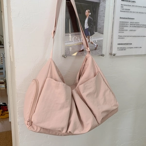 Detailansicht der rosafarbenen Nylontasche mit großen Außentaschen und Reißverschluss
