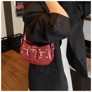 Detail of dark red patent leather hobo bag with silver studs and Y2K punk buckle