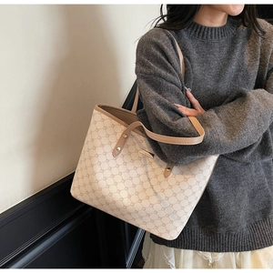 Dettaglio borsa tote beige con motivo geometrico marrone e manici in pelle