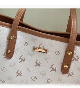 Detailansicht der weißen Tragetasche aus strukturiertem Leder mit Hirschprint und Nieten