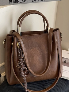 Vintage brown faux leather handbag with metal handles and adjustable shoulder strap