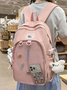 Pink Japanese style student backpack with clear front pocket and cute cartoon charms